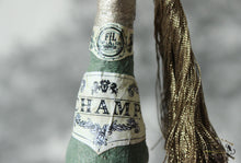 Laden Sie das Bild in den Galerie-Viewer, Cotton Ornament Champ Bottle with Tassel and Glitter (Gold)